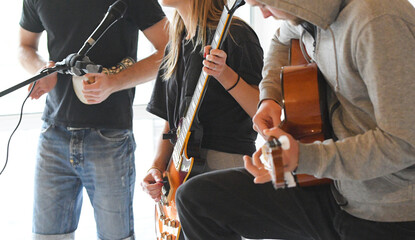 a group of young people sing and play guitar and drums