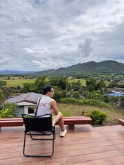Handsome Man Relaxing on Holiday at a Coffee Shop terrace with Stunning Mountain Views