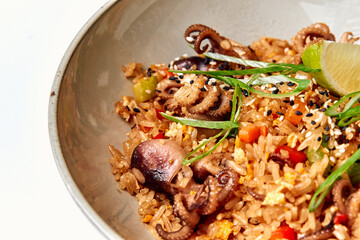Delicious Bowl of Octopus Fried Rice Garnished with Fresh Herbs and Lime for a Flavorful Culinary Experience