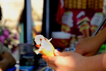 A Maraş ice cream vendor in traditional garb holds a cone. Ice-cold ice cream in the summer heat. Turkey.
