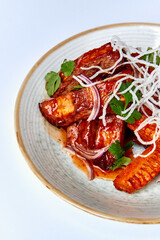 Deliciously Glazed Chicken Thighs Garnished with Fresh Herbs and Crispy Onions on a Decorative Plate
