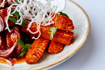 Vibrant Plate of Spicy Entrée Featuring Crispy Fried Carrots Garnished with Fresh Herbs and Crispy Noodles, Perfect for a Flavorful Culinary Experience