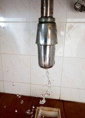 There is leak in water pipe under the sink, drain is clogged. Water Leak around pipe because sink is draining slowly and splashing in house home, high speed shutter freeze motion photo
