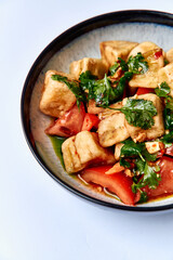 Delicious and Flavorful Vegetable and Tofu Salad Bowl with Fresh Cilantro, Tomatoes, and Flavorful Seasonings for a Healthy Meal Experience