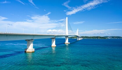 Modern white bridge spans turquoise water under a vibrant blue sky