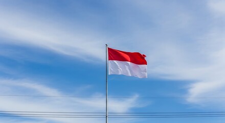 Red and White Flag Waving on a Pole Against a Blue Sky