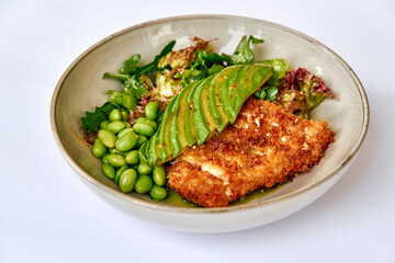 A Delectable Dish Featuring Crispy Fried Fish Served with Fresh Greens, Edamame, and Sliced Avocado for a Perfect Culinary Experience
