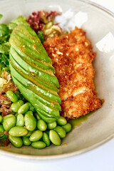 A Vibrant Bowl of Fresh Ingredients Featuring Crispy Fried Protein, Creamy Avocado Slices, Tender Edamame, and Crisp Mixed Greens in a Delightful Arrangement