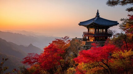 Traditional Korean mountain house and old temple pagoda surrounded by red and orange maple trees in autumn forest, with sunrise mist, distant sea, and golden hour light over peaceful scenic landscape.