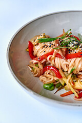 A Delicious Plate of Stir-Fried Noodles with Colorful Vegetables, Topped with Sesame Seeds and Fresh Green Onions for an Appetizing Dish