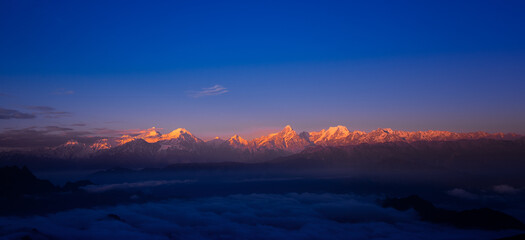At sunrise, the sun shines on the golden mountain