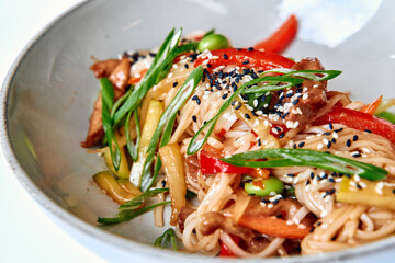 A Vibrant Stir-Fry of Noodles and Fresh Vegetables Topped with Sesame and Green Onions for a Flavorful Dish Experience