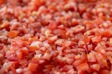 Chopped fresh cubes sliced red tomatoes on top view