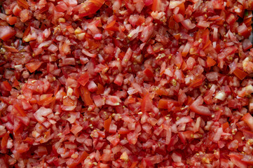 Chopped fresh cubes sliced red tomatoes on top view