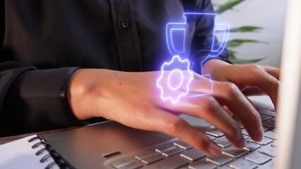 Close-up of a professional's hands using a computer with a floating virtual icon of a trophy with a gear