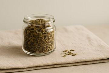 Glass Jar Filled with Dried Leaves on Soft Cloth Surface