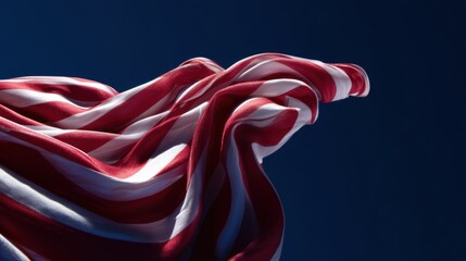 Striped red and white fabric against a deep blue background, embodying abstract patriotic symbolism with dramatic lighting