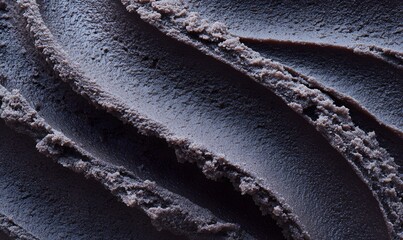 Close-up of rich, creamy black ice cream with smooth and slightly ridged texture