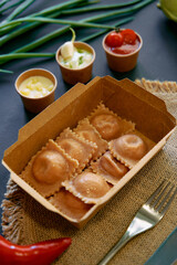 Delicious Homemade Ravioli Served Fresh with Assorted Sauces in a Rustic Setting Surrounded by Fresh Ingredients and Utensils