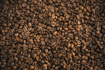 Freshly roasted coffee beans displayed in a textured background, showcasing their rich brown hues and distinct texture, ideal for concepts of coffee culture, mornings, and natural organic products.