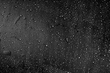 Dark Condensation Abstract. This dramatic black and white image features water droplets on a dark surface. The high contrast adds depth and visual interest, making it suitable for abstract art or edgy