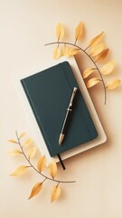Elegant stationery flat lay with notebook, pen, and decorative golden leaves