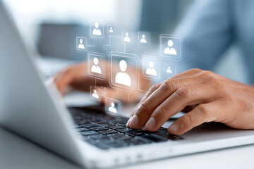 Person Engaged in Online Networking While Typing on a Laptop in a Modern Workspace During Daytime