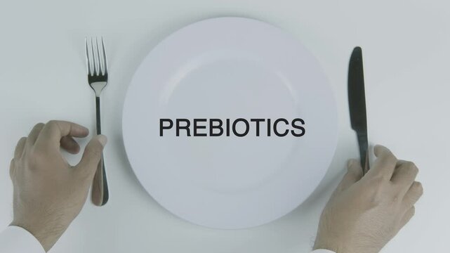 Prebiotics word on a plate with hands holding fork and knife on white background, symbolizing gut health, nutrition, and wellness concept illustration