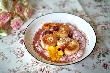 Delicate Dish of Creamy Desserts with Fresh Fruits, Garnished with Vibrant Edible Flowers on Floral Tablecloth Setting