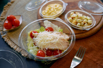 Fresh Salad with Grilled Chicken, Cherry Tomatoes, and Parmesan Cheese Accompanied by Macaroni and Croutons on a Rustic Table Setting