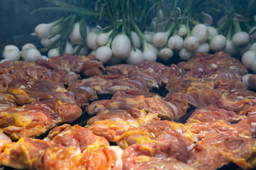 Grilled chicken breasts on a smoky barbecue grill with chambray onion 