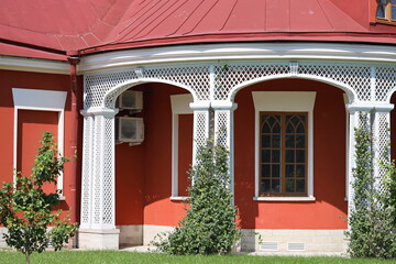 A colorful building with a bright red roof, standing amidst greenery