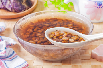 Mung bean sweet soup  in a glass bowl with a spoon on the table