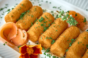Deliciously Fried Food Platter Featuring Crispy Croquettes Garnished with Fresh Herbs and Colorful Floral Accents in a Culinary Presentation