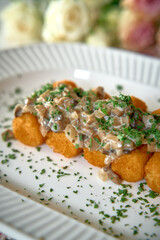 Deliciously Crafted Golden Bites Topped with Creamy Mushroom Sauce and Fresh Herbs, Perfectly Arranged for a Gourmet Culinary Experience