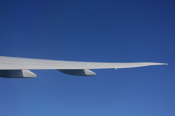 View of airplane wing against clear blue sky
