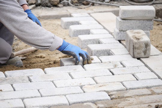 Laying gray bricks on a construction site for pathway design