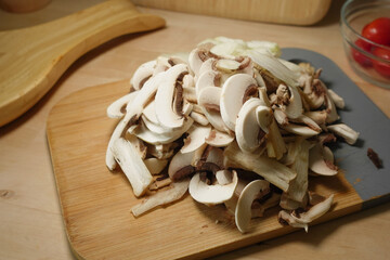 Sliced mushrooms ready for cooking on a wooden board