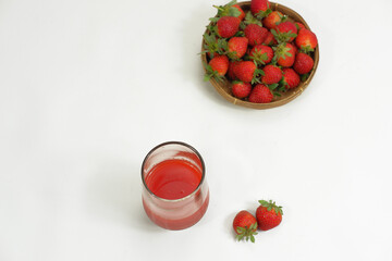 Top view of delicious fresh and ripe Strawberry Juice in a clear glass on a white background
