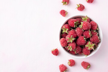 Top view of fresh ripe raspberry with leaf in bowl on pink background, Summer fruit