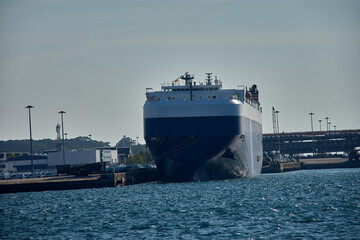 Huge car carrier ship moored in the Galician port of Vigo, with details of port facilities in the background