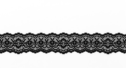 A close up shot of black lace trim with floral and scalloped edge on a white background surface