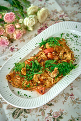 A Delicious Omelette Filled with Fresh Vegetables and Herbs, Perfectly Plated on a Floral Tablecloth Surrounded by Beautiful Flowers