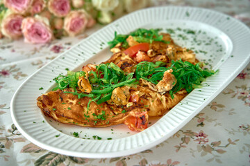 Delicious Omelette Filled with Fresh Ingredients and Topped with Green Herbs Served on a Decorative Platter Surrounded by Flowers