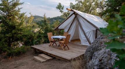 Cozy glamping tent in forested mountain landscape with wooden deck