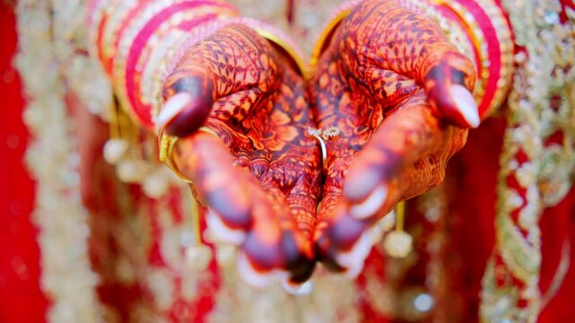 Close up view of Traditional henna painted bridal hand. Red color is the traditional Indian clothes, 