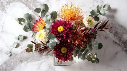 A vibrant autumn floral arrangement featuring dahlias and protea on a marble surface