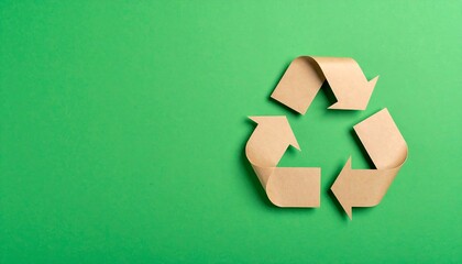 Recycled paper arrows forming a recycling symbol on green background