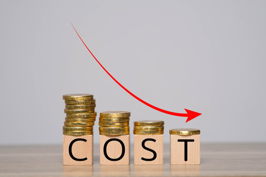 An image depicting a decreasing cost trend, illustrated by stacked coins and wooden blocks spelling "COST," with an arrow indicating a downward movement.