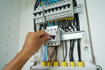 Electrician working checking a switchboard with fuses